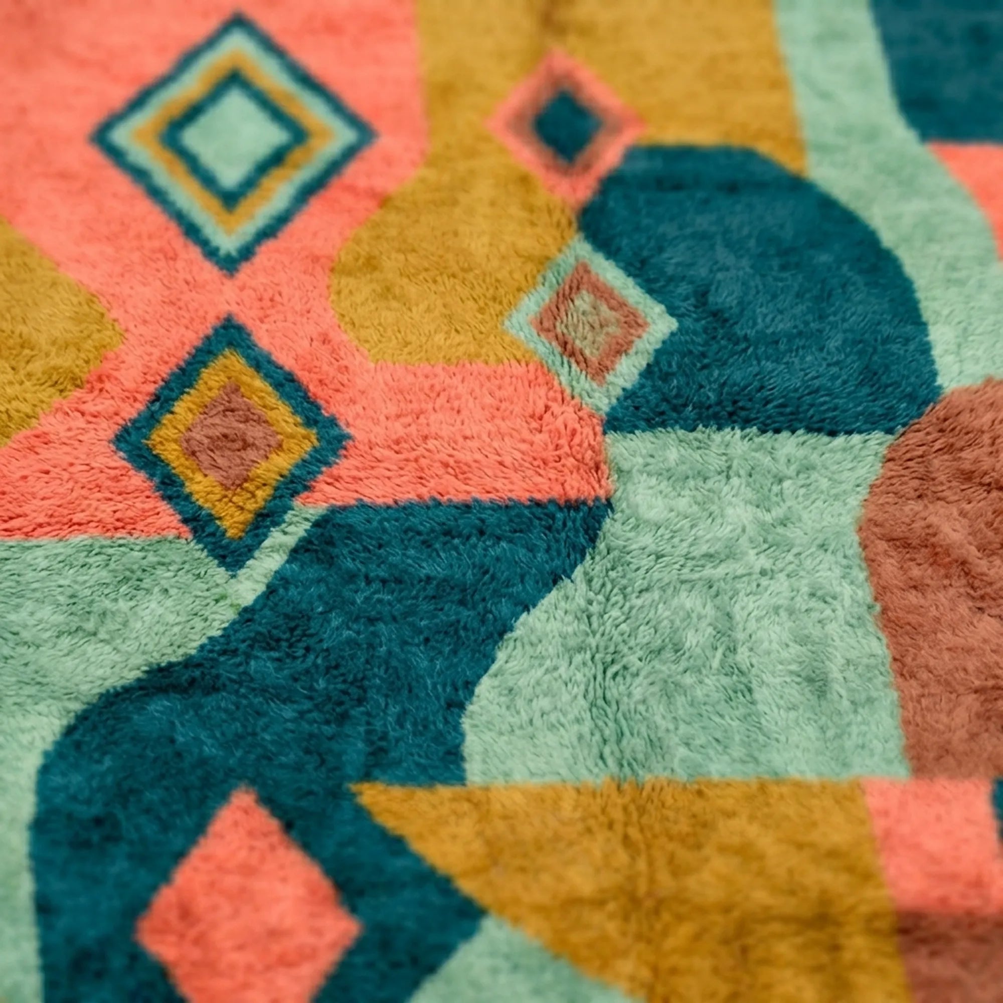 Detailed view of the Tifawin Boujaad rug showing oversized teal forms, coral blocks and small diamond motifs