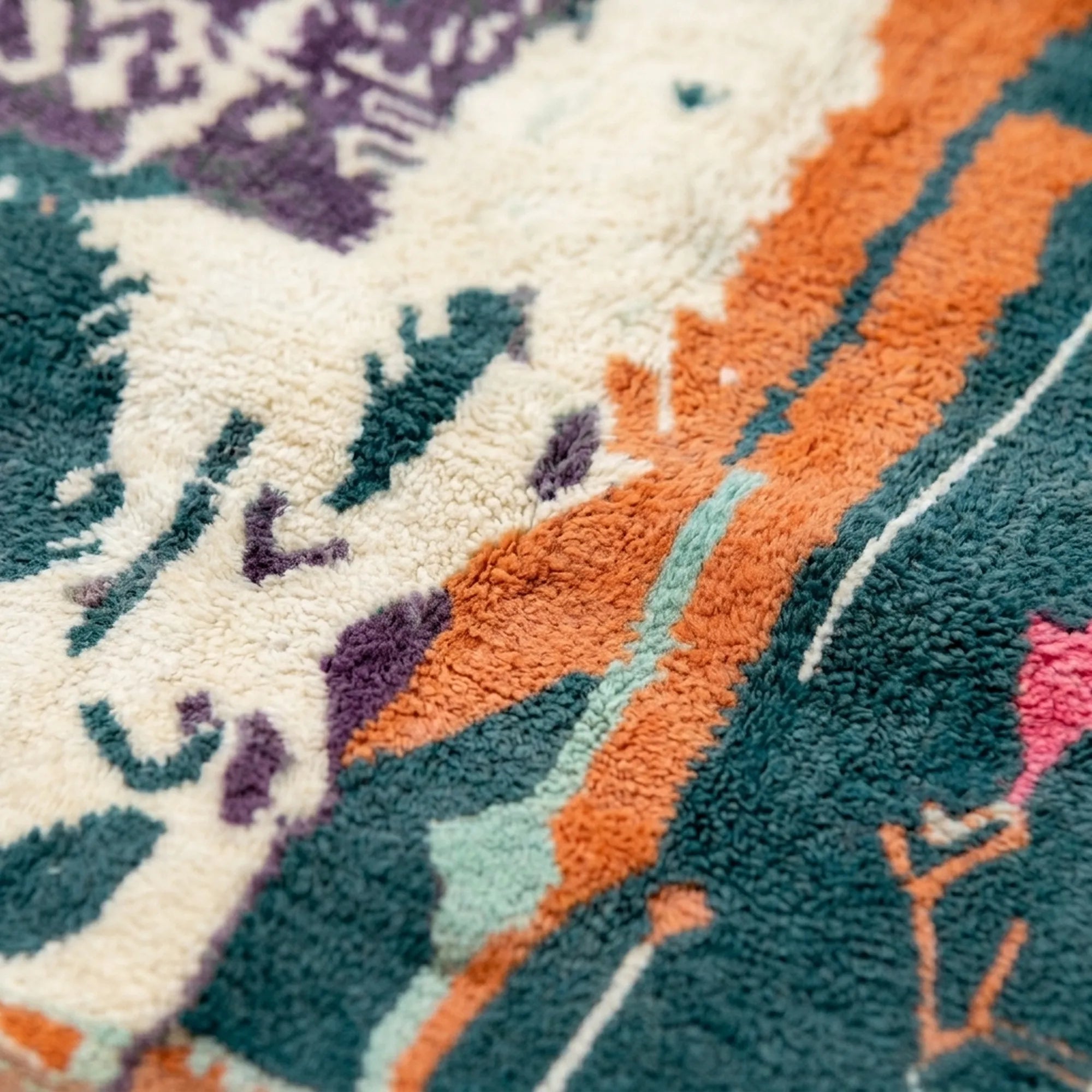 Detail of the Tafraout Boujaad rug showing small orange, purple and teal handwoven symbols