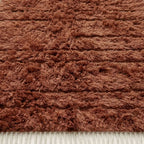 Close-up of terracotta Beni Ourain pile texture showing soft wool and horizontal band detail