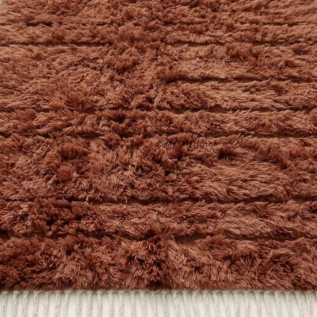 Close-up of terracotta Beni Ourain pile texture showing soft wool and horizontal band detail