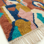 Fringe and wool-pile detail of the Ilyan Boujaad rug in terracotta, blush, teal and ochre