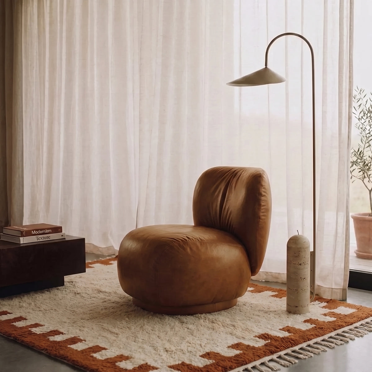 Terracotta and ivory Beni Ourain rug in modern living room with brown leather chair and arc lamp