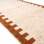 Close-up of Beni Ourain pile texture showing soft wool and crenellated border detail