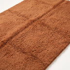 Close-up of thick soft wool pile on terracotta Beni Ourain rug showing texture and depth
