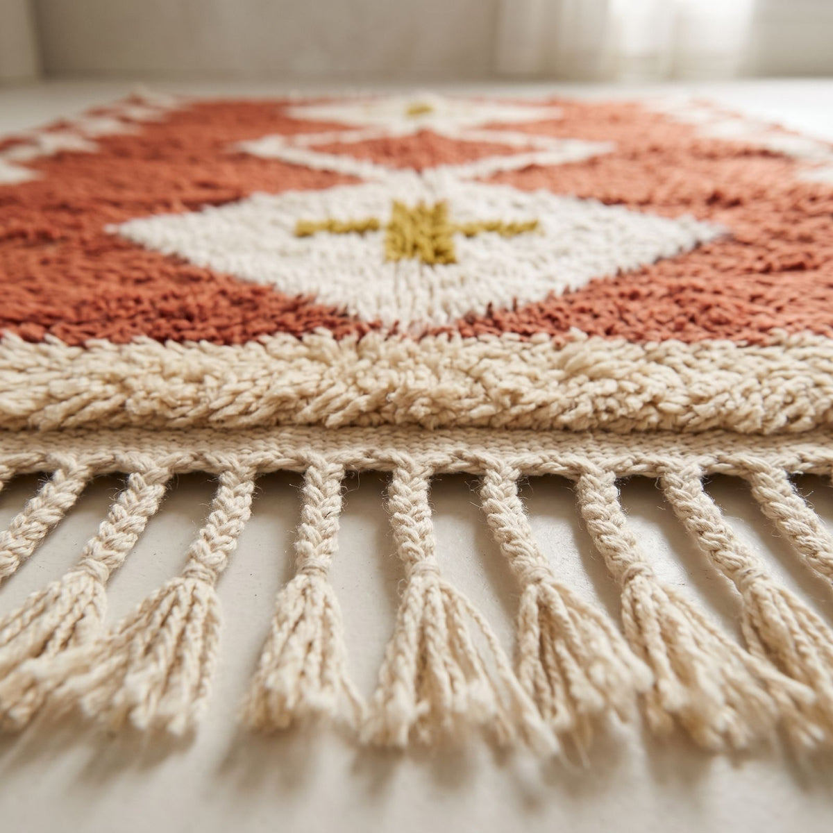 Terracotta and ivory Beni Ourain rug showing fringe edge and woven border detail