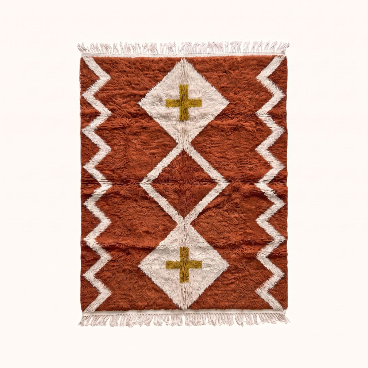 Terracotta and ivory Beni Ourain rug with diamond lattice and mustard cross design, flat lay on plain background