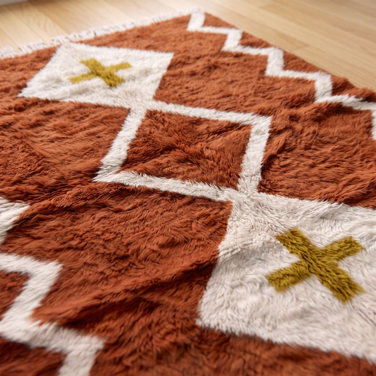 Close-up of terracotta and ivory Beni Ourain rug showing soft wool pile and diamond cross motif