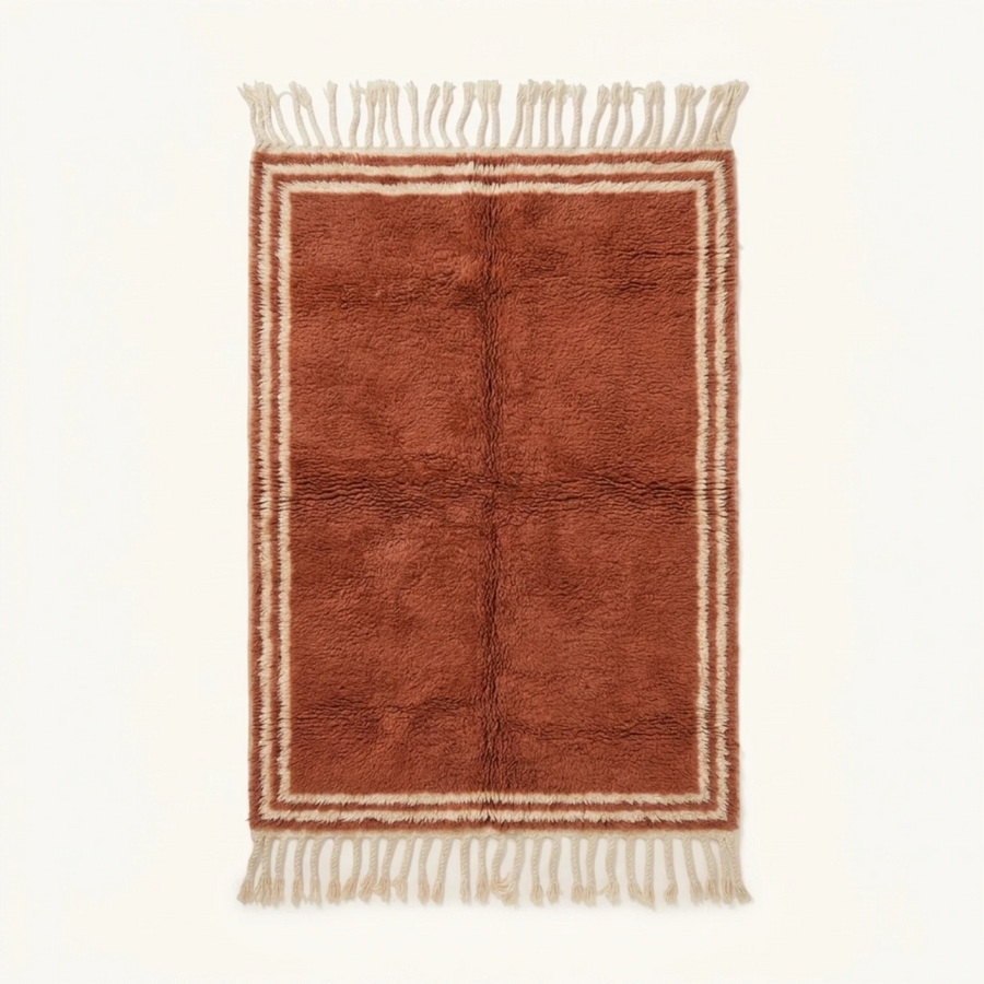 Full view of the Tislit terracotta and ivory Beni Ourain rug with a double border design and hand-tied fringe.