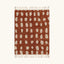 Full view of the Agdal terracotta and ivory Beni Ourain rug with an oval grid design.