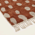 Close-up of the natural Atlas wool pile on the Agdal terracotta and ivory Beni Ourain rug.
