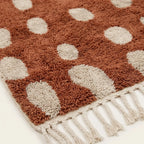 Hand-finished artisan detail of the Agdal terracotta and ivory Beni Ourain rug.