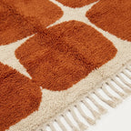 Close-up of the terracotta rounded grid pattern on the Tifawt ivory wool rug.