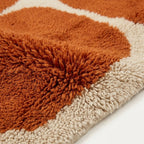 Close-up of the natural Atlas wool texture on the Tifawt terracotta and ivory rug.