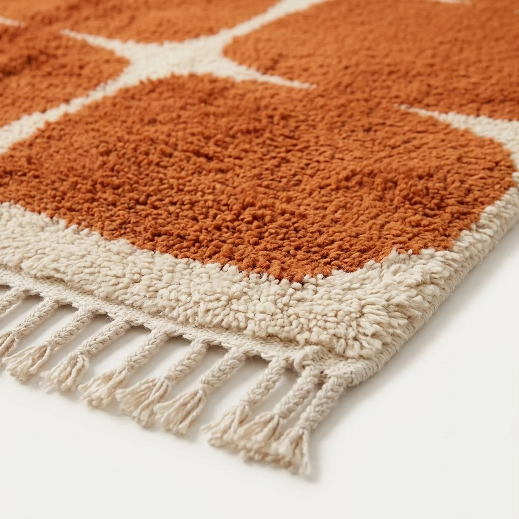 Fringe and edge detail of the Tifawt terracotta and ivory hand-knotted rug.