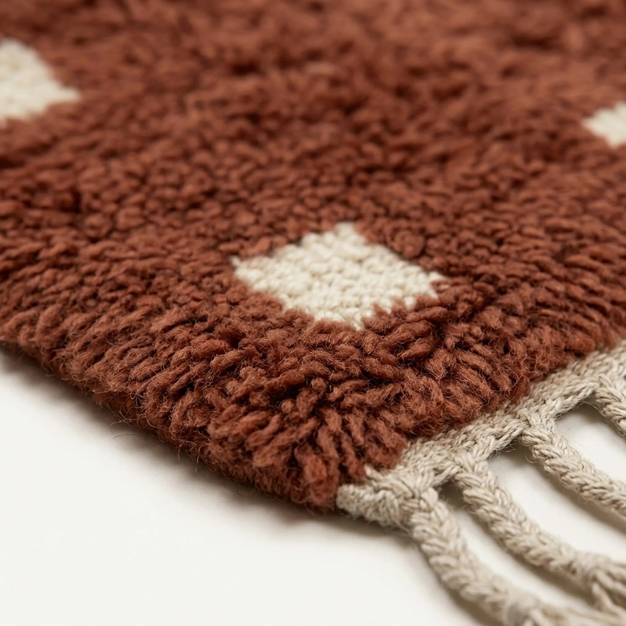 Angled detail of the terracotta and ivory hand-knotted wool rug.