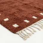Natural wool pile detail on the terracotta and ivory square border rug.