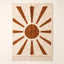 Terracotta and ivory Beni Ourain rug with sun rays motif: central circle surrounded by radiating trapezoid rays on plain background
