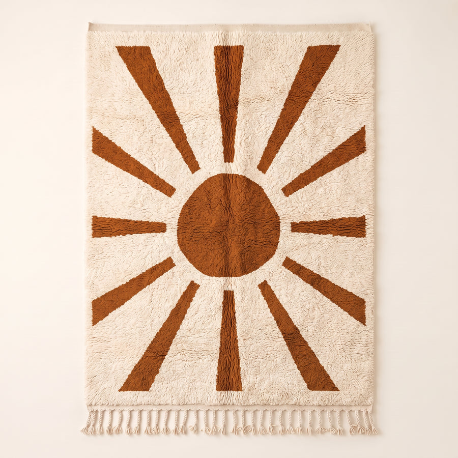Terracotta and ivory Beni Ourain rug with sun rays motif: central circle surrounded by radiating trapezoid rays on plain background