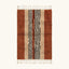 Full view of the Azar terracotta, ivory and black Beni Ourain rug with a central stripe design.