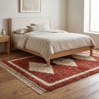 Terracotta and ivory Boujaad rug on wooden floor beside bed with cream bedding