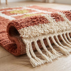 Twisted cream fringe and folded edge detail of terracotta Mrirt rug