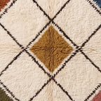 Close-up of thick soft pile showing gold diamond centre surrounded by cream squares and dark brown lattice lines on Beni Ourain rug
