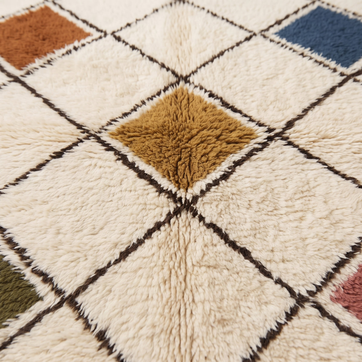 Close-up of thick pile texture showing gold and terracotta diamond centres with dark brown lattice outlines and ivory ground on Beni Ourain rug