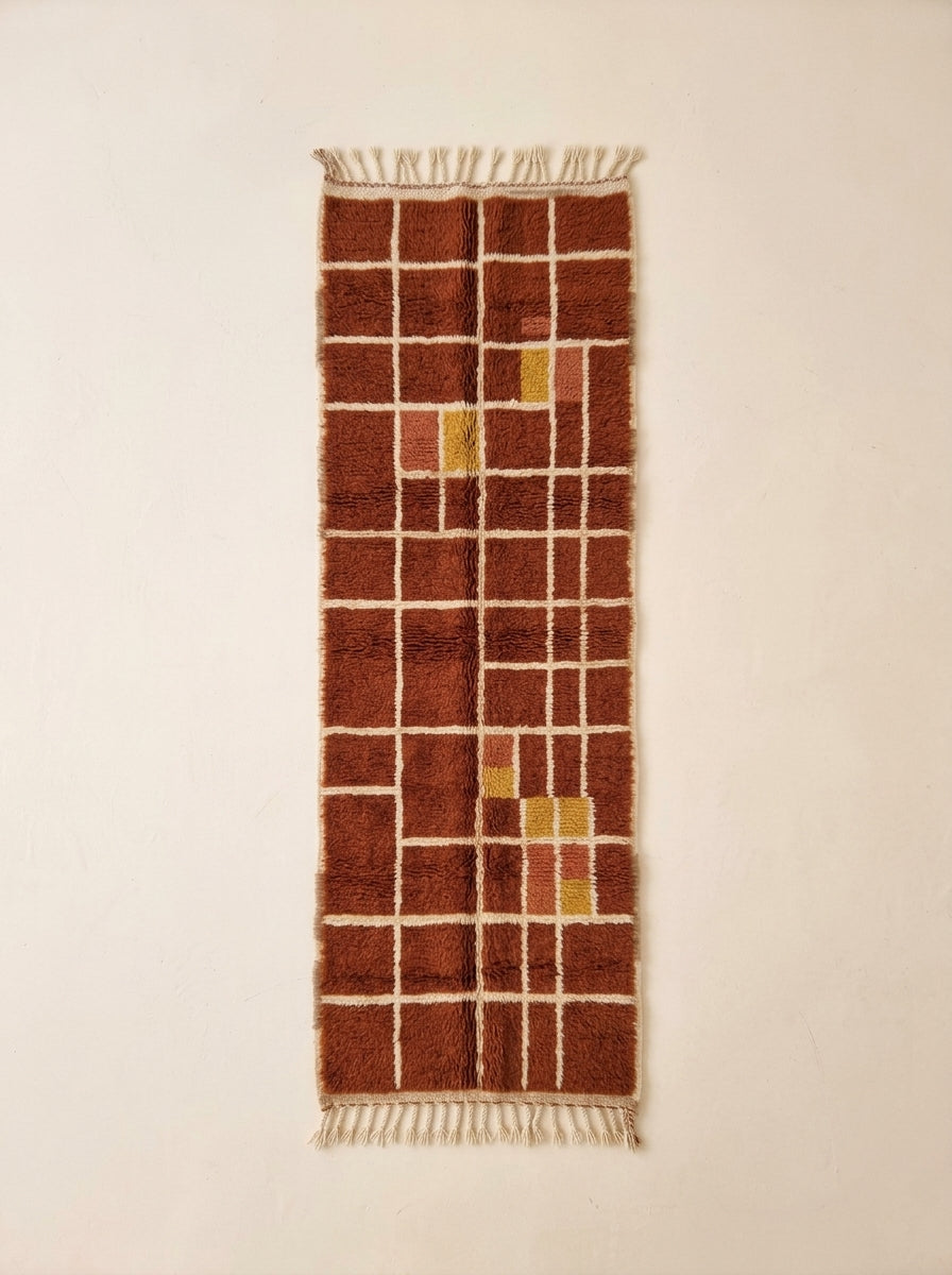 Terracotta, rust and mustard yellow Mrirt runner with cream grid check pattern, shown flat on plain background