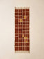 Terracotta, rust and mustard yellow Mrirt runner with cream grid check pattern, shown flat on plain background