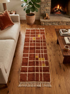 Terracotta Mrirt runner placed in front of beige sofa by fireplace with wooden floor