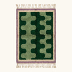 Full view of the Tifawt Beni Ourain rug with forest-green and sage abstract forms, an ivory border and lavender trim.
