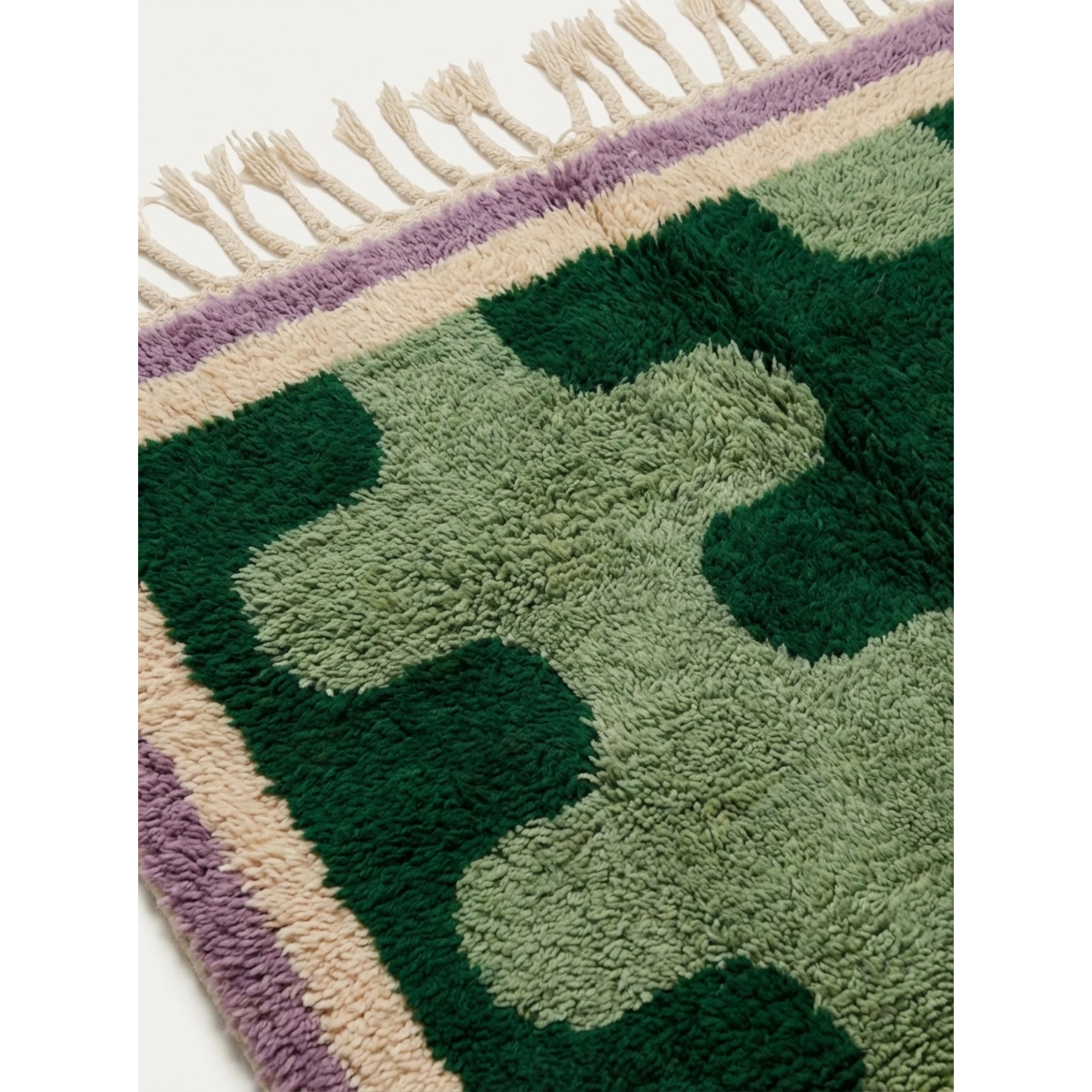 Close-up of the Tifawt rug showing forest-green and sage abstract wool forms.