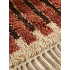 Hand-tied fringe and wool pile detail of the Tifrit terracotta rug.