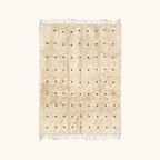 Full view of the Tislit ivory Beni Ourain rug with small black cross motifs.