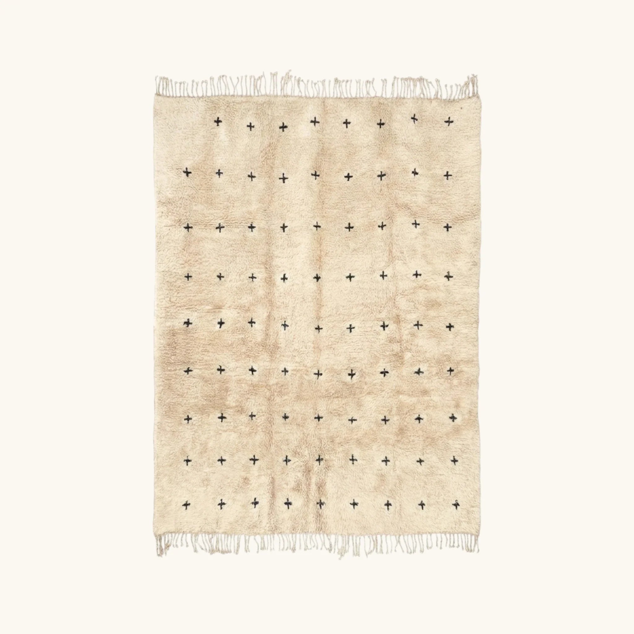 Full view of the Tislit ivory Beni Ourain rug with small black cross motifs.