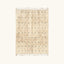 Full view of the Tislit ivory Beni Ourain rug with small black cross motifs.