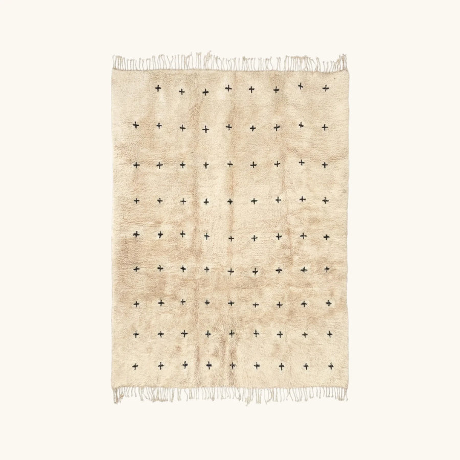 Full view of the Tislit ivory Beni Ourain rug with small black cross motifs.