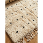 Detailed view of the black cross pattern across the Tislit ivory Moroccan rug.