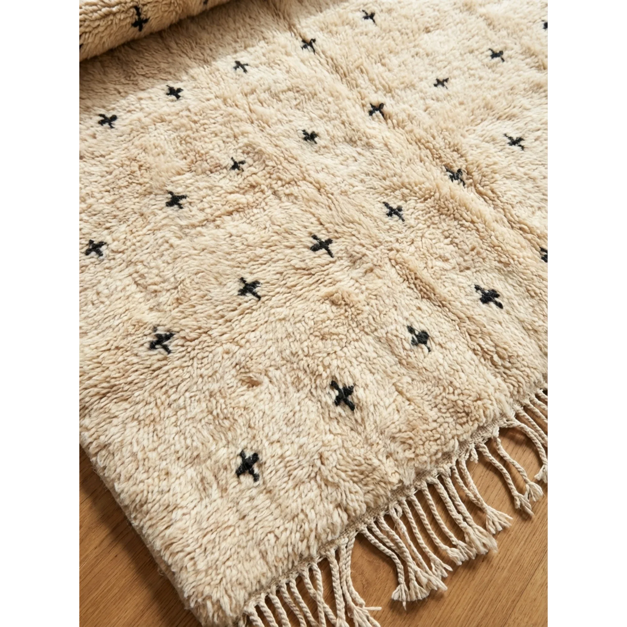 Detailed view of the black cross pattern across the Tislit ivory Moroccan rug.