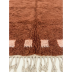 Close-up of the terracotta and ivory border block motif on the Tiziri rug.