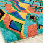 Border and edge detail of the Anir Boujaad rug in turquoise and coral.