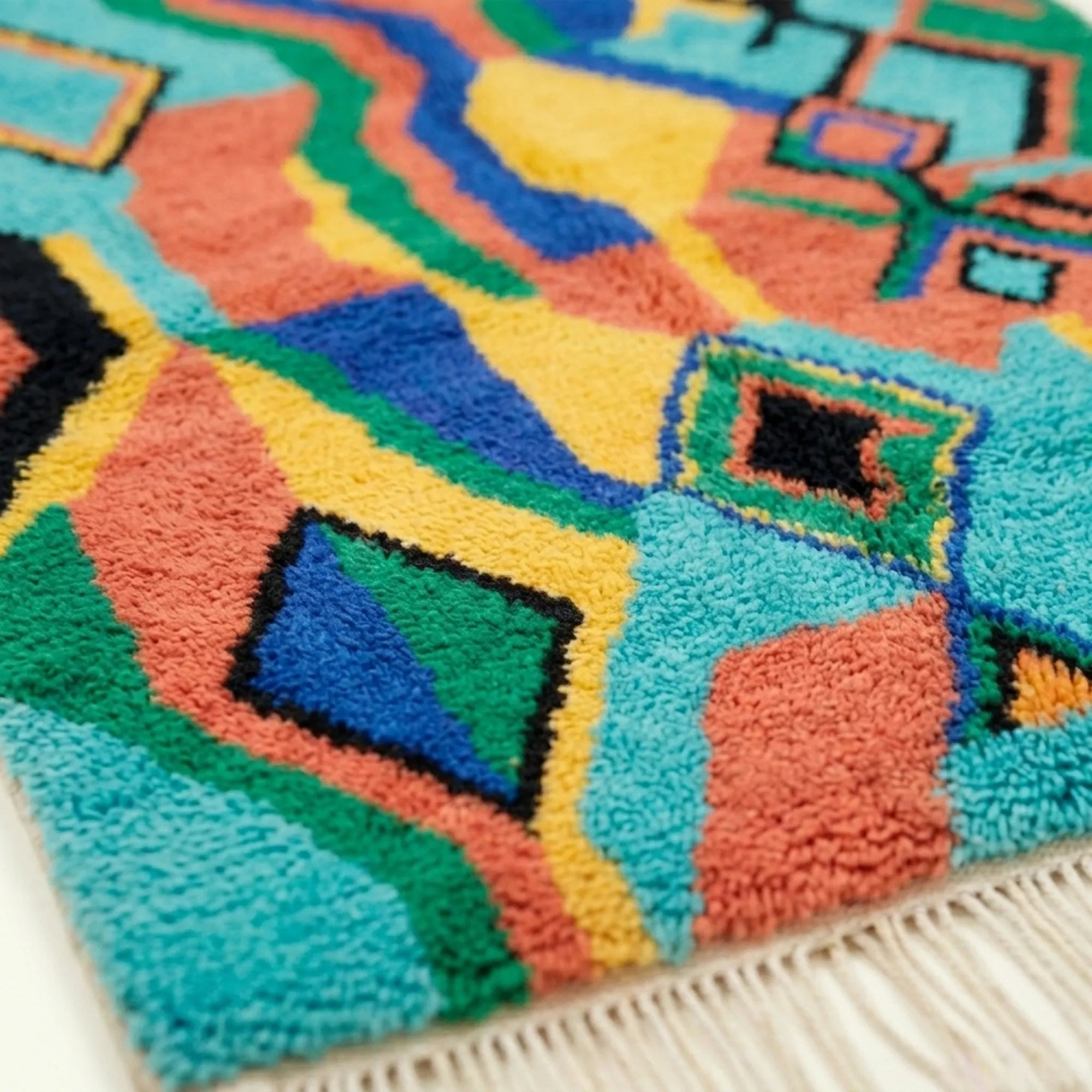Border and edge detail of the Anir Boujaad rug in turquoise and coral.