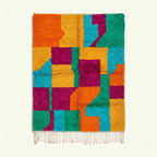 Full view of the Itri turquoise, orange and magenta Boujaad rug with a checkerboard color-block design.