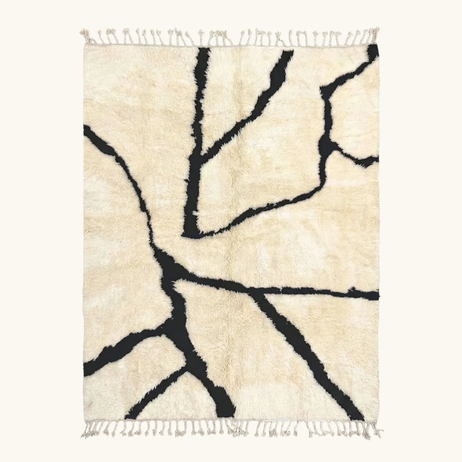 Full view of the Inur warm ivory and black Beni Ourain rug with a branch line design.