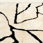 Close view of the black branch line pattern on the Inur warm ivory Beni Ourain rug.