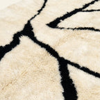 Close-up of the natural Atlas wool pile on the Inur warm ivory and black Beni Ourain rug.