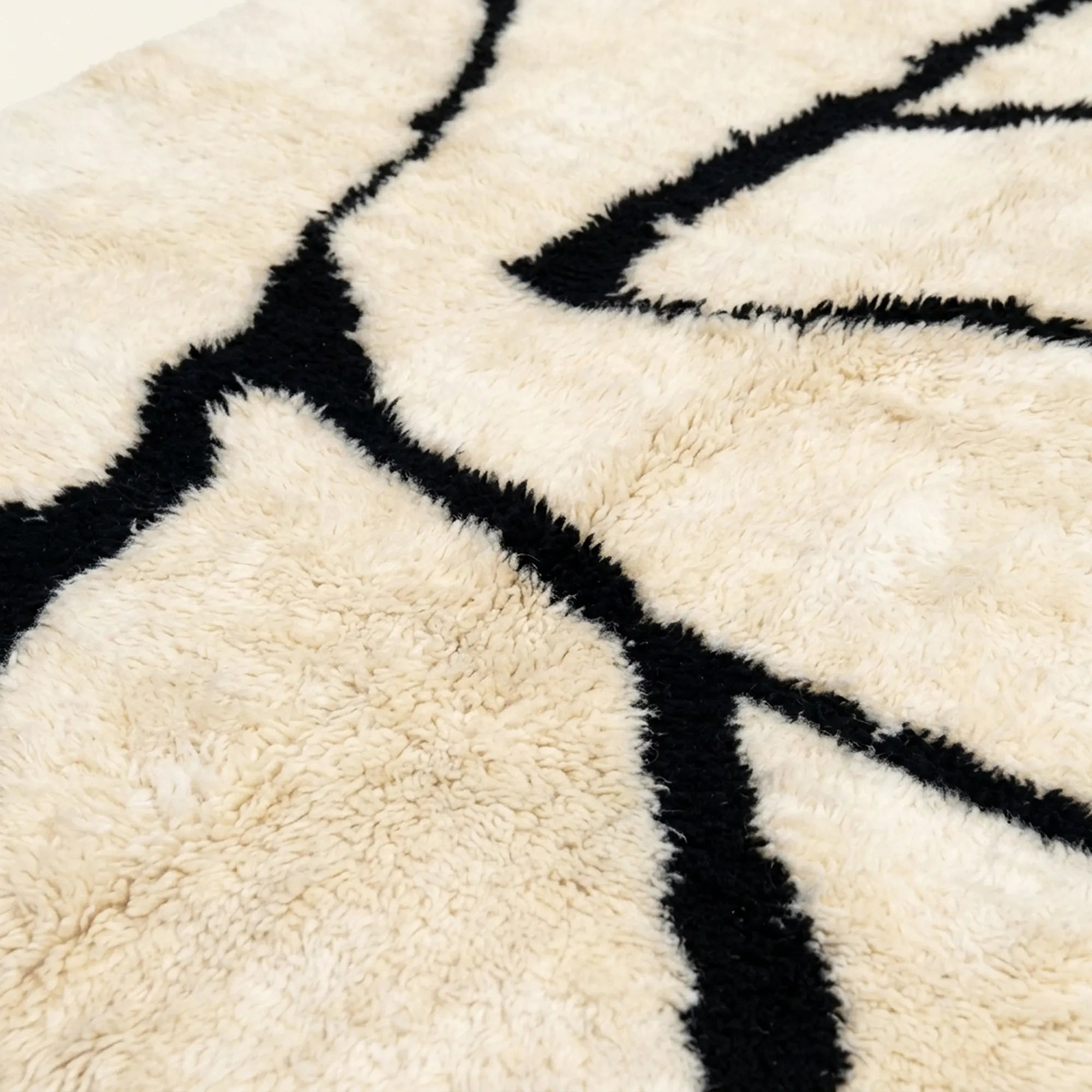 Close-up of the natural Atlas wool pile on the Inur warm ivory and black Beni Ourain rug.
