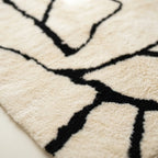 Hand-finished detail of the Inur warm ivory and black Beni Ourain rug.