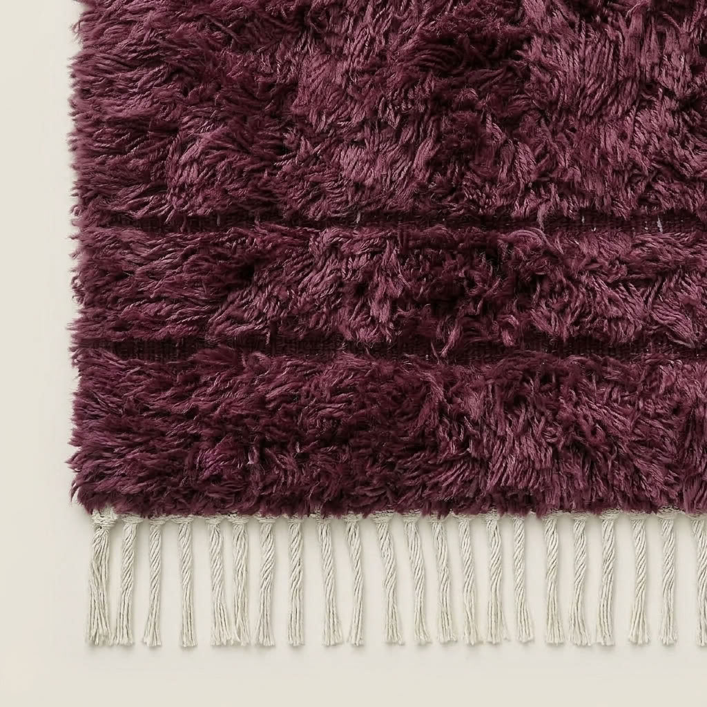 Detail shot of wine Beni Ourain rug corner and fringe, showing cream knotted fringe edge