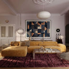 Wine Beni Ourain rug in contemporary living room under tan sectional sofa with pale walls and modern lighting